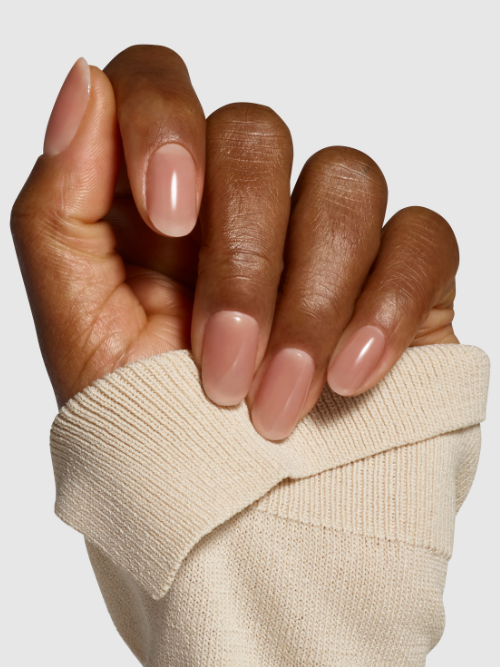 Undressed taupe nude latte nail polish on nails. Semi-sheer, wet look, glossy finish. 